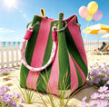 Knitted pink and green stripe handbag on a beach