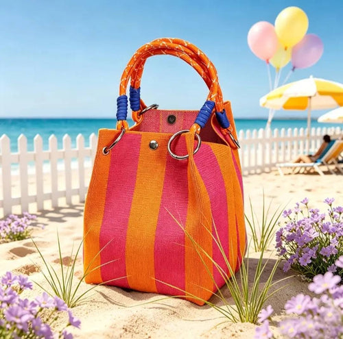 Knitted orange and hot pink stripe handbag on a beach